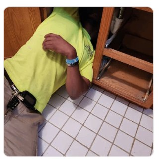 Plumbing work under a cabinet